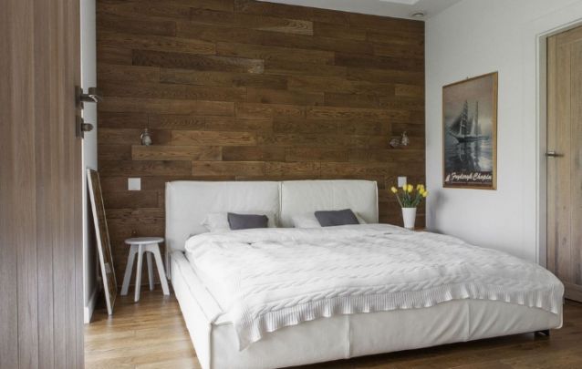 A parede de madeira atrás da cama deixa este ambiente moderno com traços do estilo rústico A parede de madeira atrás da cama deixa este ambiente moderno com traços do estilo rústico