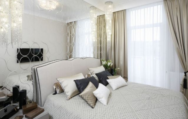 O espelho atrás da cama auxilia na sensação de profundidade neste quarto feminino pequeno O espelho atrás da cama auxilia na sensação de profundidade neste quarto feminino pequeno